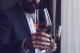 Mann im Sakko hält Weinglas mit Rotwein in der Hand