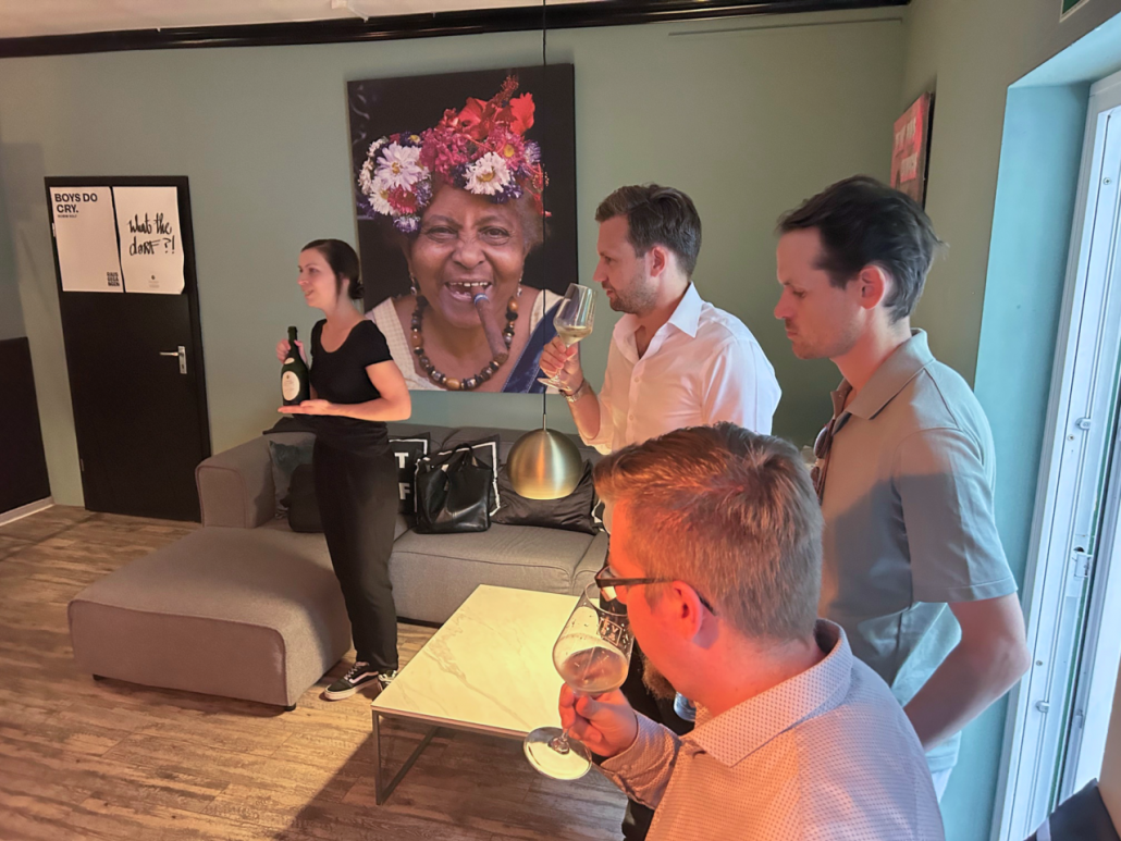 a group of people standing in a room with a picture of a woman